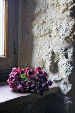 Terre cuite, plafond en poutres apparentes, murs de pierre enduits à la chaux, et meubles patinés, cette chambre forme un ensemble représentatif des options de décoration prises dans le cadre de réhabilitation.